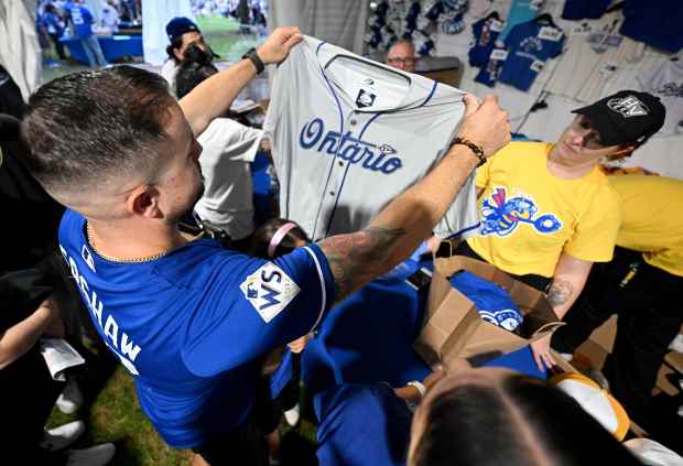 Dodger fan Robert Sanchez, from Ontario, holds up an Ontario...