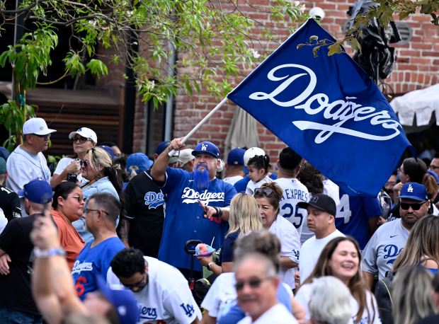 A Dodger fan waves a team flag during the official...