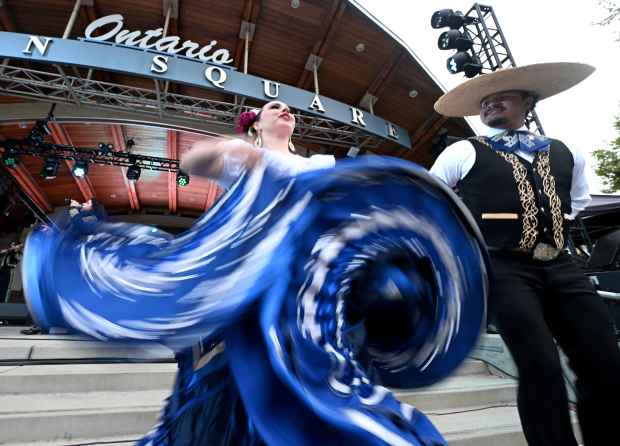 A ballet folklorico group performs for Dodger fans as they...