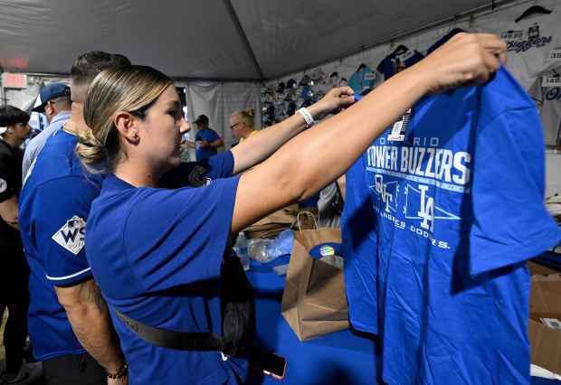 Dodger fan Christina Sanchez, from Ontario, holds up an Ontario...