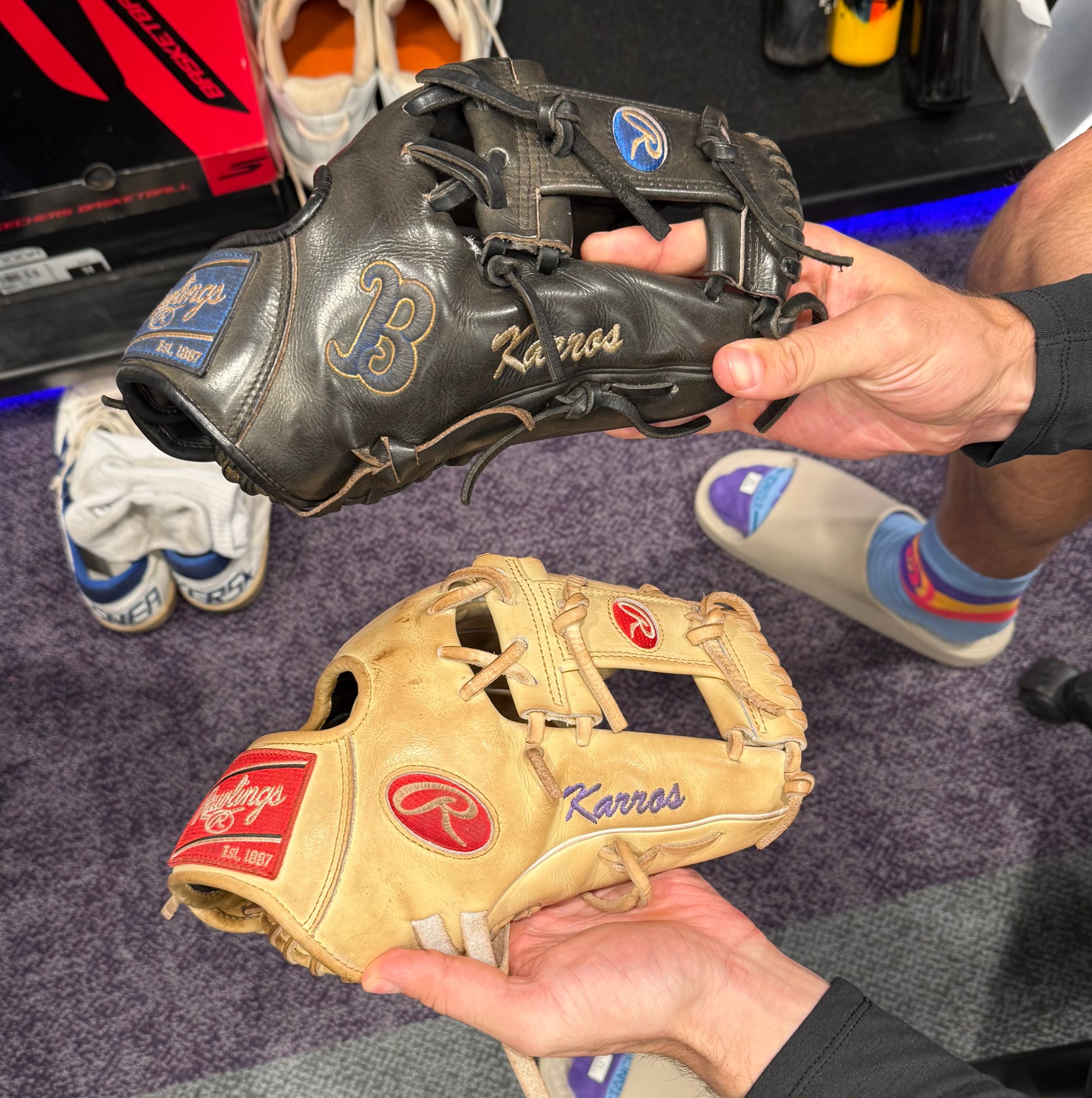 Kyle Karros holds two gloves, one his UCLA glove and the other, the glove he is using now.