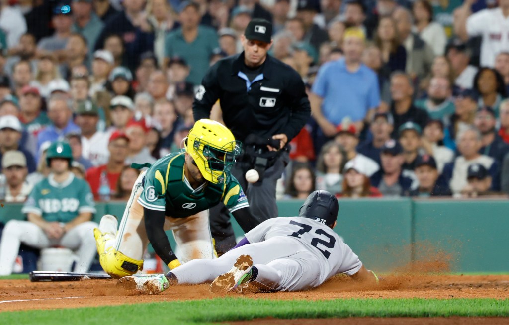 José Caballero dives safely into home to score a run in the seventh inning of the Yankees' win over the Red Sox.