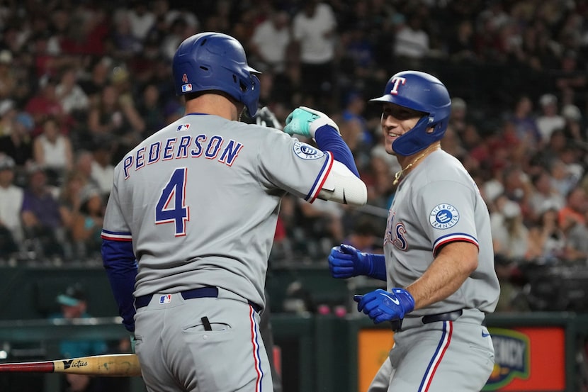 Texas Rangers' Wyatt Langford celebrates with Joc Pederson (4) after hitting a solo home run...