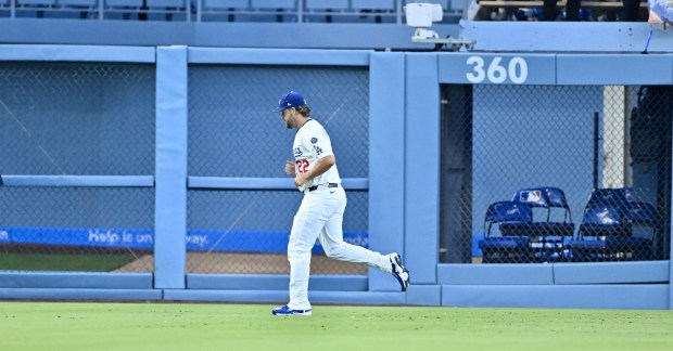 Dodgers starting pitcher Clayton Kershaw jogs in the outfield before...