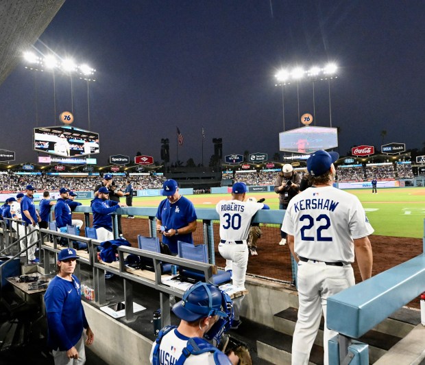 Dodgers starting pitcher Clayton Kershaw stands in the dugout before...