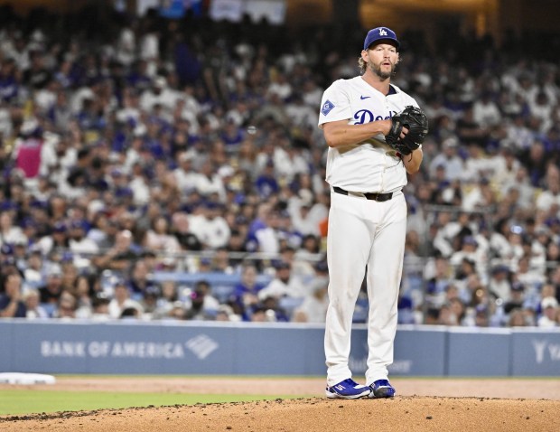 Dodgers starting pitcher Clayton Kershaw prepares to throw to the...