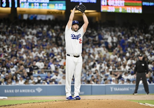 Dodgers starting pitcher Clayton Kershaw prepares to throw to the...