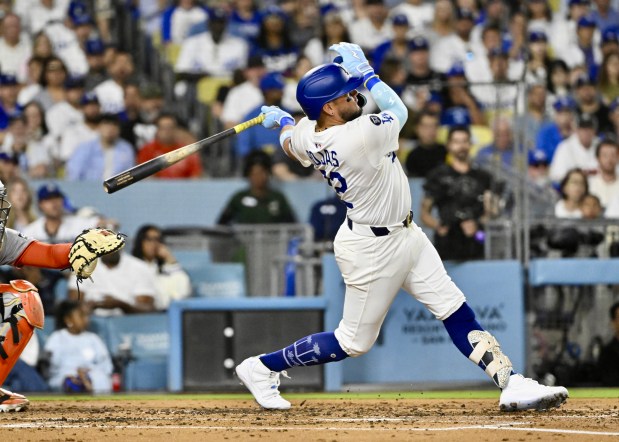The Dodgers’ Miguel Rojas hits a solo home run during...