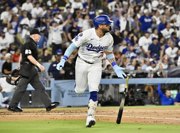 The Dodgers’ Miguel Rojas begins to run the bases as...