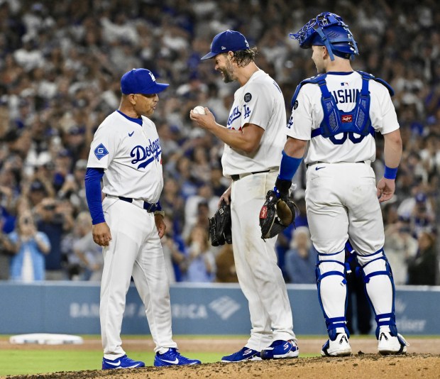 Dodgers starting pitcher Clayton Kershaw shows the game ball to...
