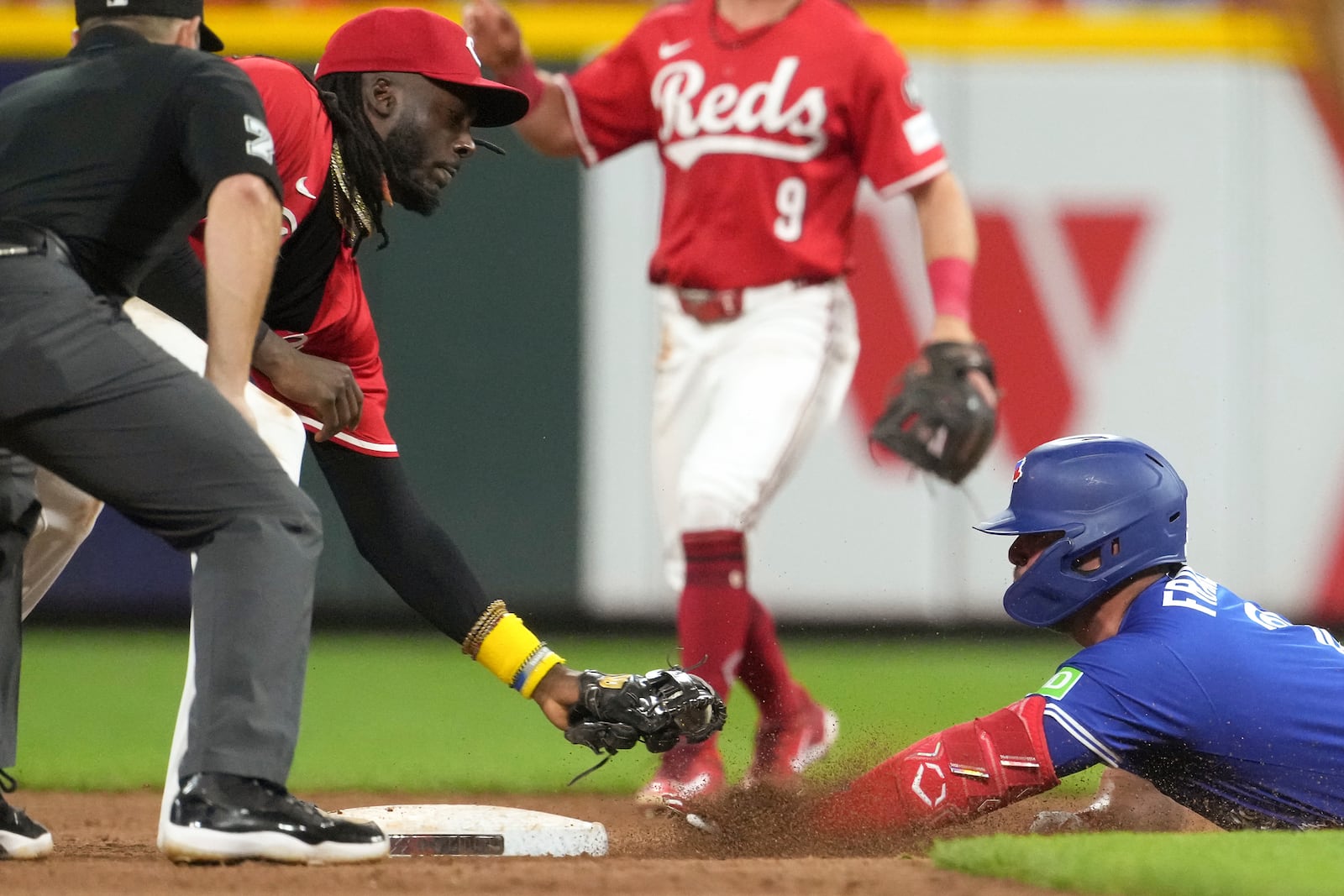 Toronto Blue Jays' Ty France, right, slides into second base safely after hitting a double before Cincinnati Reds' Elly De La Cruz, left, can apply the tag in the eighth inning of a baseball game Tuesday, Sept. 2, 2025, in Cincinnati. (AP Photo/Kareem Elgazzar)
