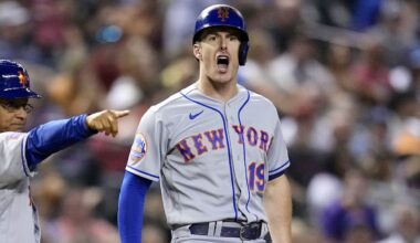 New York Mets' Mark Canha (19) celebrates his RBI triple against the Arizona Diamondbacks, while third base coach Joey Cora points to the right side of the infield during the ninth inning of a baseball game Wednesday, July 5, 2023, in Phoenix.