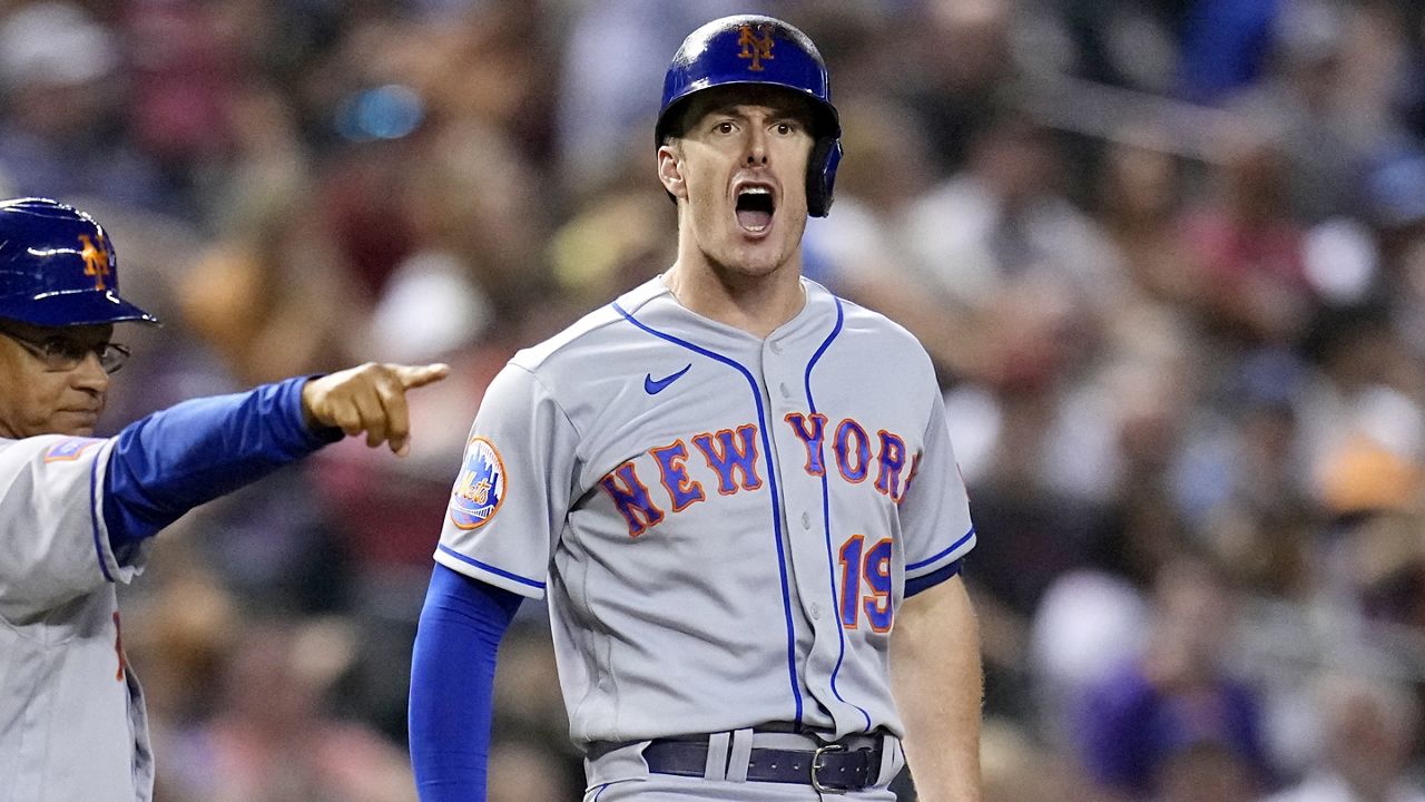 New York Mets' Mark Canha (19) celebrates his RBI triple against the Arizona Diamondbacks, while third base coach Joey Cora points to the right side of the infield during the ninth inning of a baseball game Wednesday, July 5, 2023, in Phoenix.