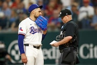 Texas Rangers starting pitcher Nathan Eovaldi (17) talks with umpire Todd Tichenor (13)...