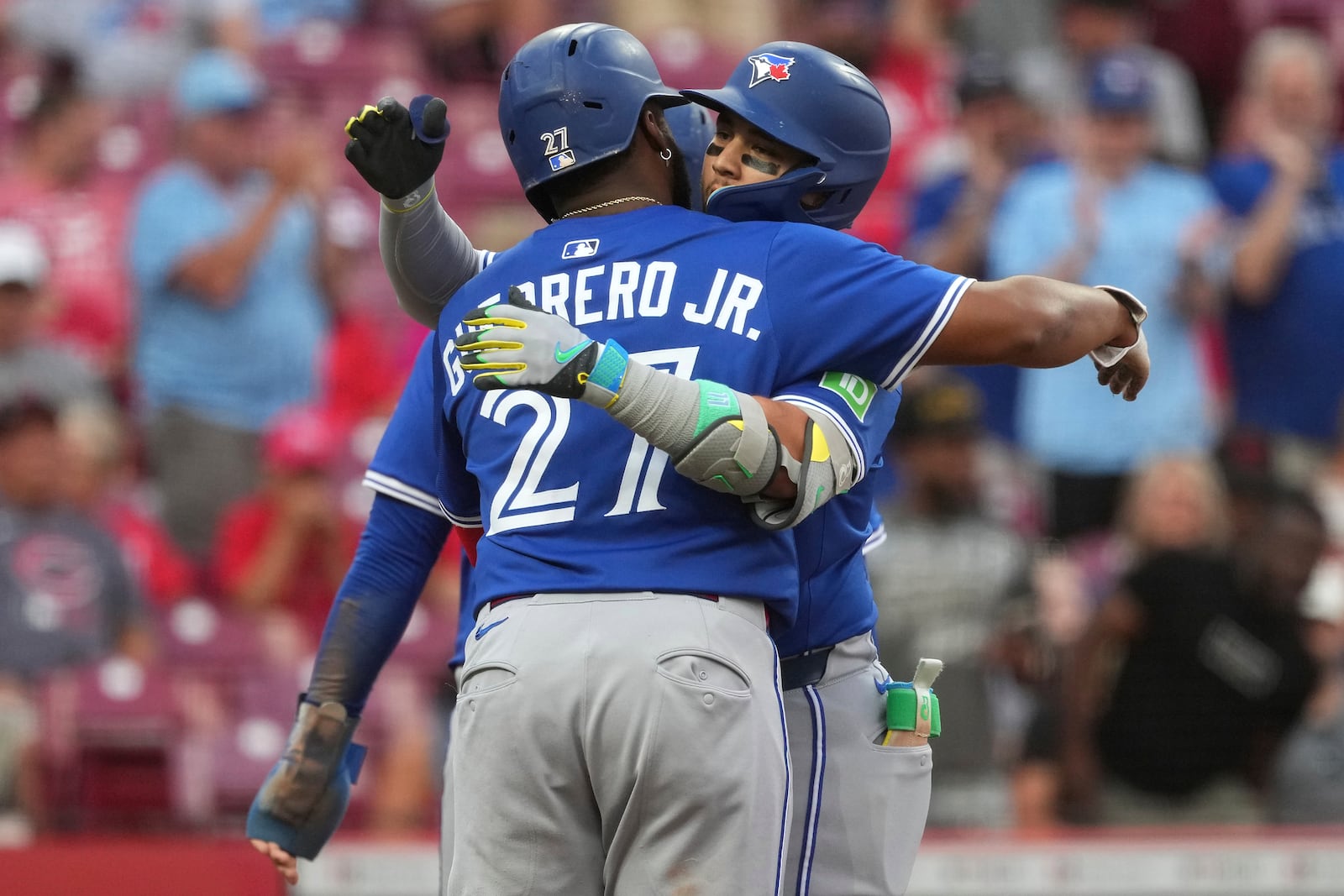 Toronto Blue Jays' Bo Bichette, right, hugs Vladimir Guerrero Jr., left, after hitting a three-run home run in the second inning of a baseball game against the Cincinnati Reds, Tuesday, Sept. 2, 2025, in Cincinnati. (AP Photo/Kareem Elgazzar)
