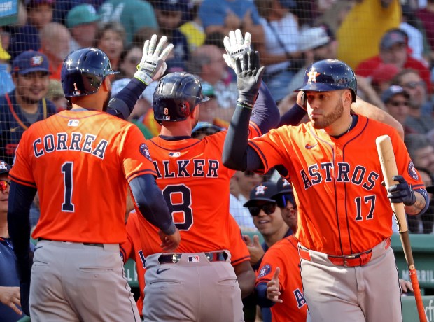 Houston Astros first base Christian Walker (8) is congratulated on his 2 run HR along with Houston Astros Carlos Correa (1) as the Sox take on the Astros. (Staff Photo By Stuart Cahill/Boston Herald)