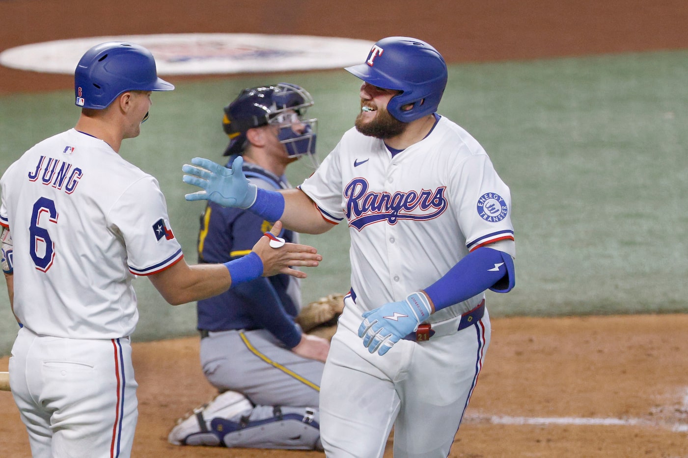 Texas Rangers first base Jake Burger (21) gets a high-five from his teammate  Josh Jung (6)...