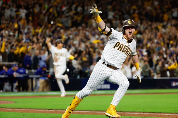 San Diego Padres' Jake Cronenworth, right, celebrates while headed to first on the go-ahead two-run double as Ha-Seong Kim heads to home during the seventh inning in game 4 of the NLDS against the Los Angeles Dodgers at Petco Park on Saturday, Oct. 15, 2022 in San Diego, CA. (K.C. Alfred / The San Diego Union-Tribune)