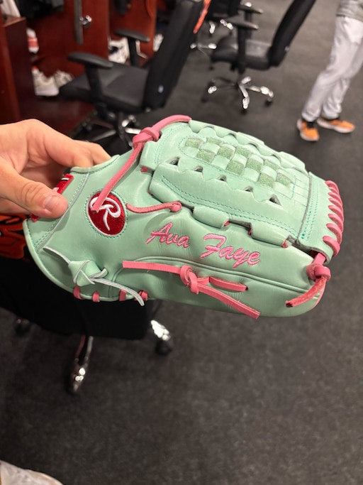 Orioles pitcher Tyler Wells holds his new glove, which sports his daughter's name.