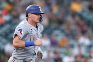 Texas Rangers' Josh Jung runs to first base after hitting a single during the second inning...