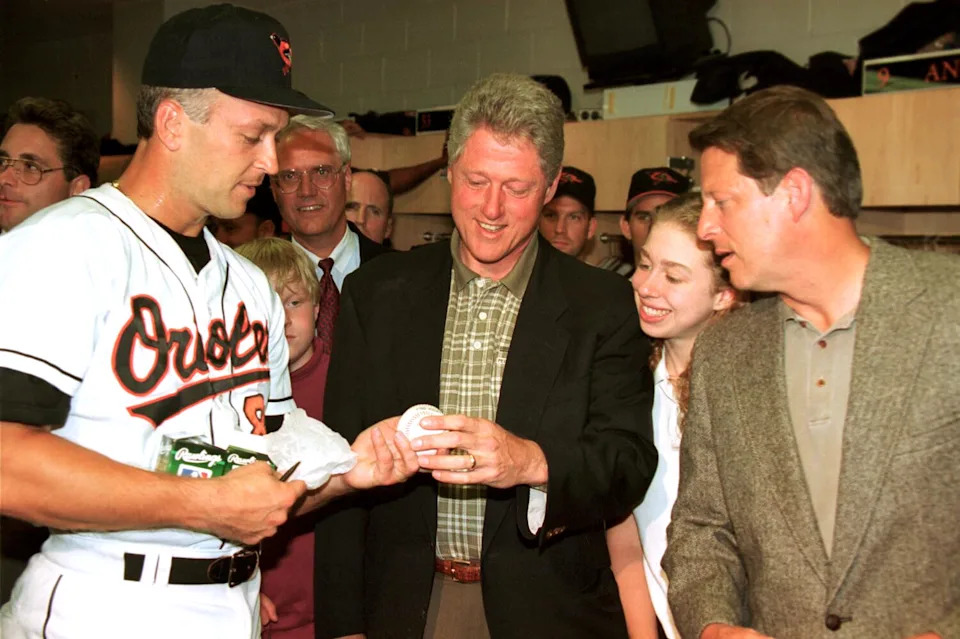 President Bill Clinton is handed an autographed ball by Baltimore Orioles shortstop Cal Ripken Jr.