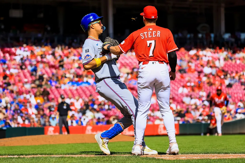 Sep 7, 2025; Cincinnati, Ohio, USA; Cincinnati Reds first baseman Spencer Steer (7) tags New York Mets pinch hitter Mark Vientos (27) out at first in the eighth inning at Great American Ball Park. Mandatory Credit: Katie Stratman-Imagn Images