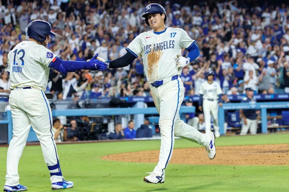 Dodgers star Shohei Ohtani celebrates with Max Muncy after scoring in the fourth inning against the Giants on Saturday.