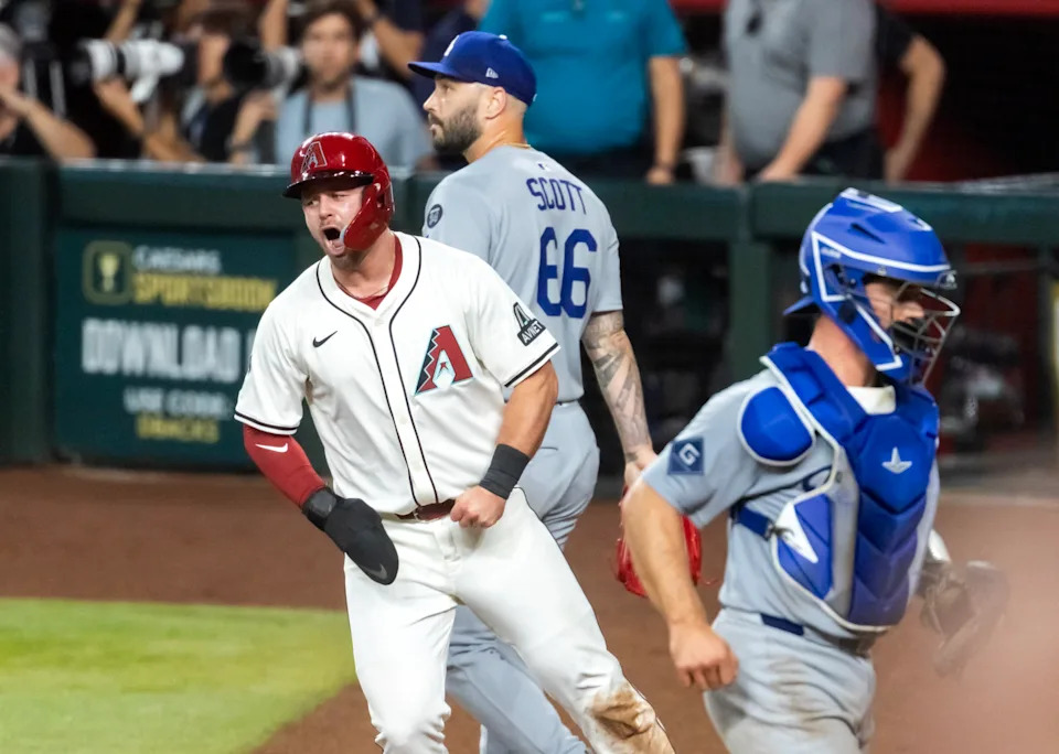 Sep 23, 2025; Phoenix, Arizona, USA; Arizona Diamondbacks base runner Tim Tawa (13) celebrates after scoring the winning run as Los Angeles Dodgers pitcher Tanner Scott (66) and catcher Ben Rortvedt react in the ninth inning at Chase Field. Mandatory Credit: Mark J. Rebilas-Imagn Images
