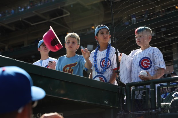 Young fans get autographs from Cubs third base coach Quintin Berry before a game against the Braves at Wrigley Field on Sept. 1, 2025, in Chicago. (John J. Kim/Chicago Tribune)