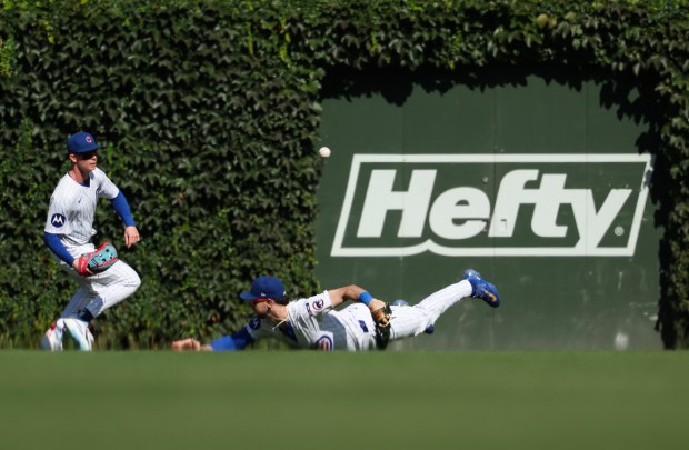 Cubs right fielder Kyle Tucker falls to the turf as center fielder Pete Crow-Armstrong fields a ball hit by Braves center fielder Michael Harris II for a two-run single in the third inning at Wrigley Field on Sept. 1, 2025, in Chicago. (John J. Kim/Chicago Tribune)