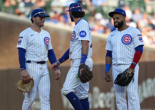 Newly-acquired Cubs first baseman Carlos Santana, right, talks with teammates in the tenth inning against the Braves at Wrigley Field on Sept. 1, 2025, in Chicago. (John J. Kim/Chicago Tribune)