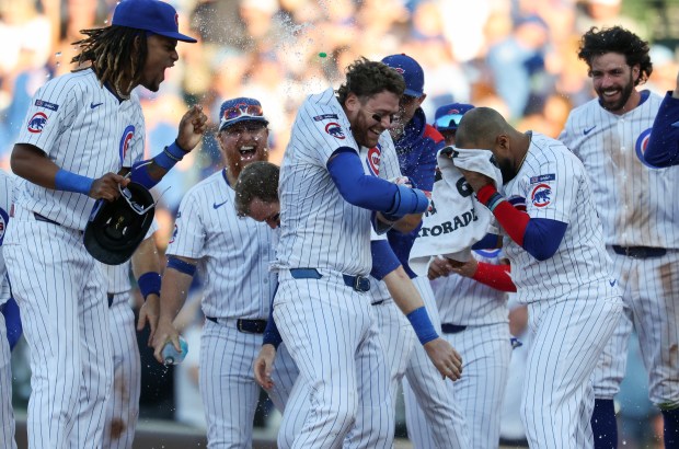 Cubs catcher Carson Kelly, center, is congratulated by teammates after hitting a game-winning RBI single in the tenth inning against the Braves at Wrigley Field on Sept. 1, 2025, in Chicago. (John J. Kim/Chicago Tribune)