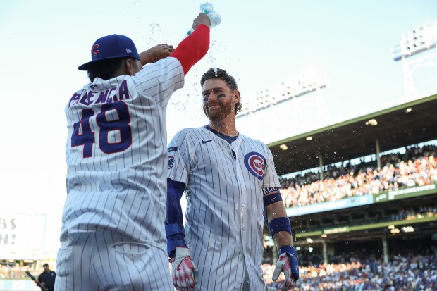 Cubs catcher Carson Kelly gets doused with water by pitcher Daniel Palencia after hitting a game-winning RBI single in the tenth inning against the Braves at Wrigley Field on Sept. 1, 2025, in Chicago. (John J. Kim/Chicago Tribune)