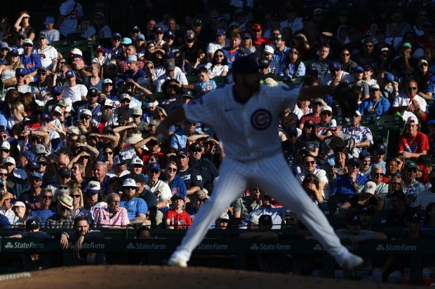 Fans shield their eyes from the setting sun as Cubs pitcher Aaron Civale throws in the eighth inning against the Braves at Wrigley Field on Sept. 1, 2025, in Chicago. (John J. Kim/Chicago Tribune)