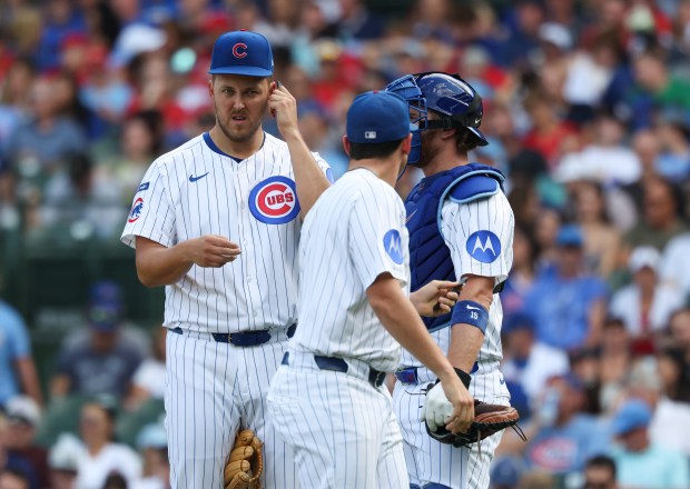 Cubs starting pitcher Jameson Taillon, left, has his electronic receiver switched in the fifth inning against the Cardinals at Wrigley Field on Sept. 27, 2025, in Chicago. (John J. Kim/Chicago Tribune)