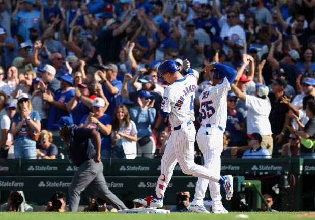 Cubs left fielder Pete Crow-Armstrong gets a high-five from first base coach Jose Javier while rounding the bases after hitting a two-run home run in the eighth inning against the Cardinals at Wrigley Field on Sept. 27, 2025, in Chicago. (John J. Kim/Chicago Tribune)