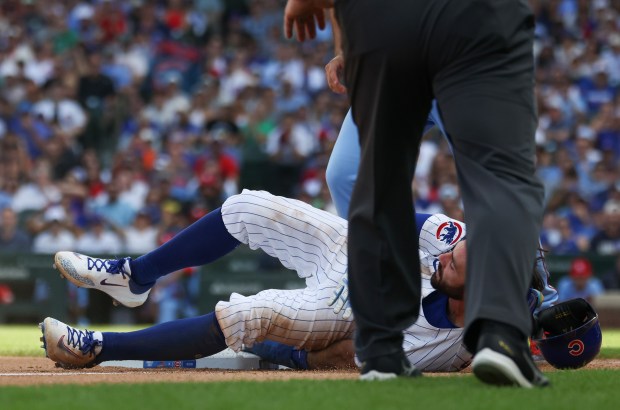 Cubs shortstop Dansby Swanson keeps his hand on the base after stealing third in the eighth inning against the Cardinals at Wrigley Field on Sept. 27, 2025, in Chicago. (John J. Kim/Chicago Tribune)