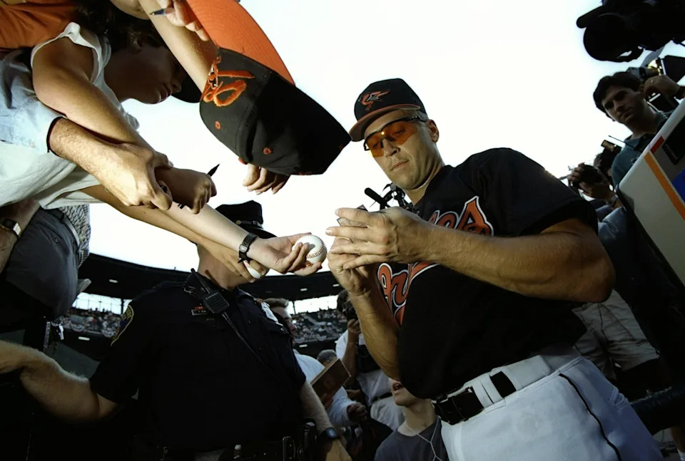 Cal Ripken signs autographs for fans before the game he broke Lou Gehrig's record.