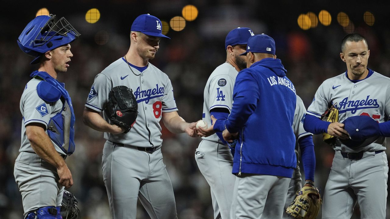 Los Angeles Dodgers pitcher Jack Dreyer, second from left, hands the ball over to manager Dave Roberts as he exits during the ninth inning of a baseball game against the San Francisco Giants, Friday, Sept. 12, 2025, in San Francisco. (AP Photo/Godofredo A. Vásquez)