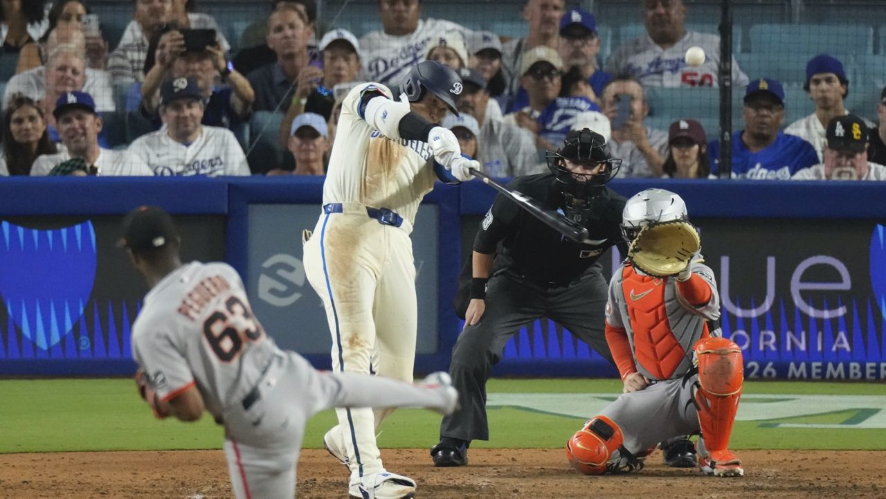Los Angeles Dodgers' Shohei Ohtani, second from left, heads hits a solo home run as San Francisco Giants relief pitcher Joel Peguero, left, and catcher Patrick Bailey watch during the sixth inning of a baseball game, Saturday, Sept. 20, 2025, in Los Angeles. (AP Photo/Mark J. Terrill)