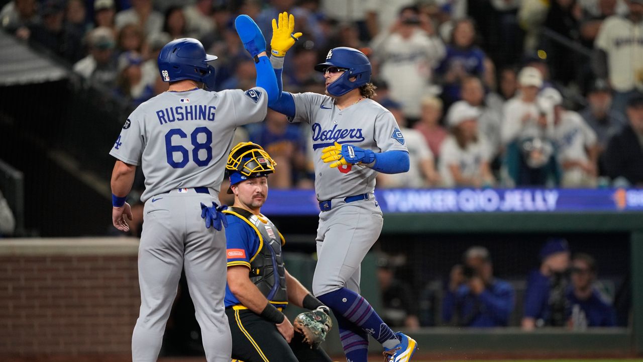 Los Angeles Dodgers' Kiké Hernandez (8) celebrates with Dalton Rushing (68) after hitting a two-run home run to score Rushing during the third inning of a baseball game against the Seattle Mariners, Friday, Sept. 26, 2025, in Seattle. (AP Photo/Ryan Sun)