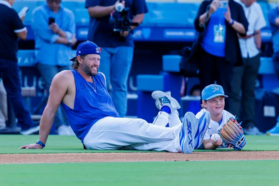 Dodgers pitcher Clayton Kershaw sits on the field at Dodger Stadium with his son Charlie.