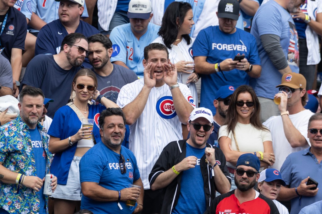 Chicago Cubs fans cheering at a baseball game.