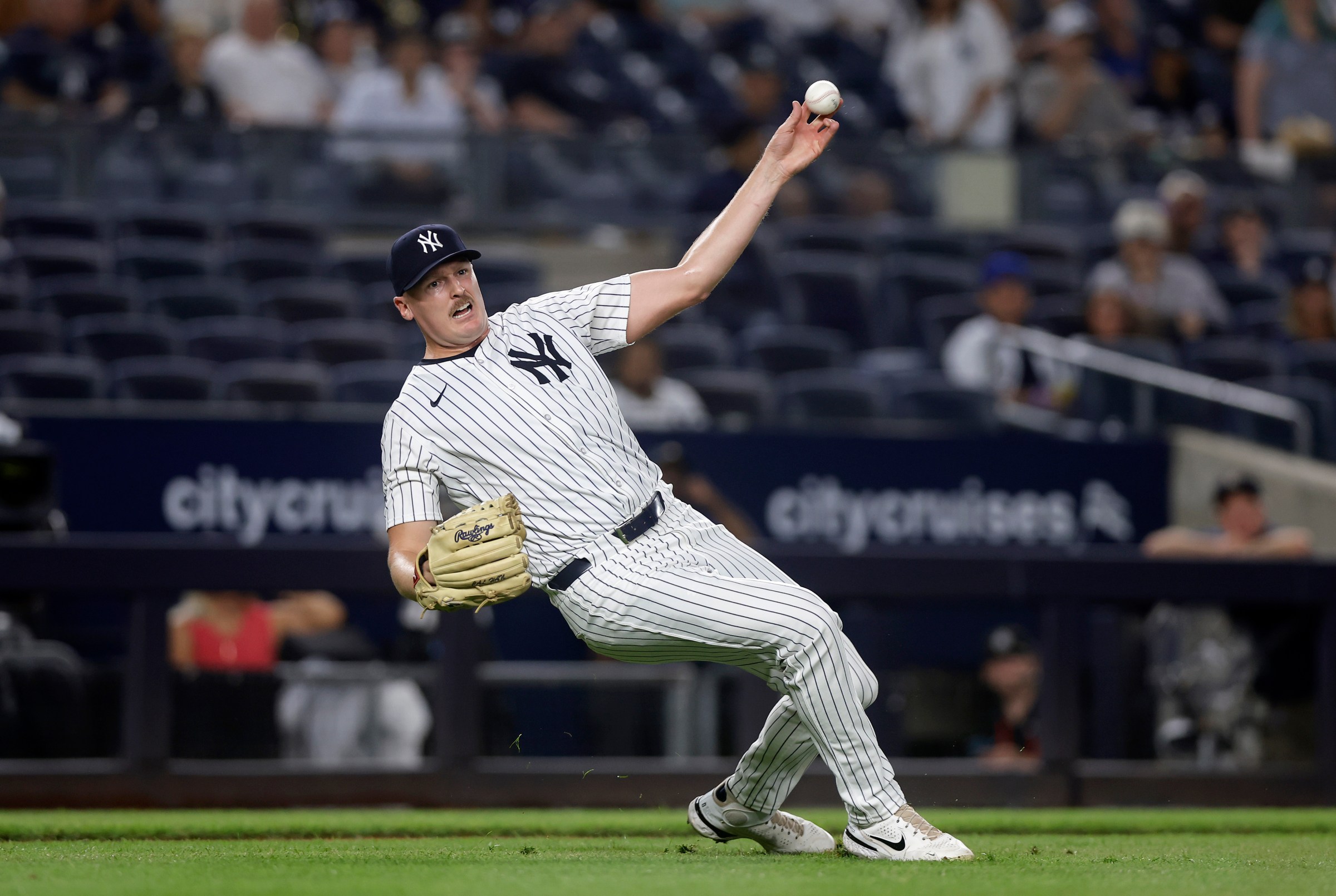 NEW YORK, NEW YORK - AUGUST 13: Brent Headrick #47 of the New York Yankees attempts a throw to first base after he was hit by a batted ball in the ninth inning against the Minnesota Twins at Yankee Stadium on August 13, 2025 in New York City. (Photo by Jim McIsaac/Getty Images)