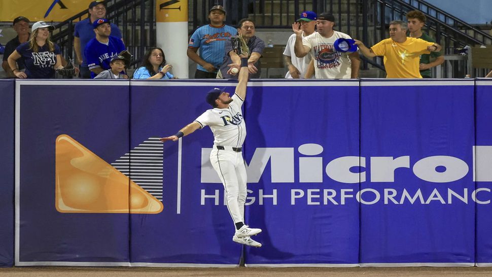 Tampa Bay Rays outfielder Josh Lowe jumps for a hit by Toronto Blue Jays' Nathan Lukes that was eventually ruled a home run after review during the fourth inning of a baseball game Tuesday, Sept. 16, 2025, in Tampa, Fla. (AP Photo/Mike Carlson)