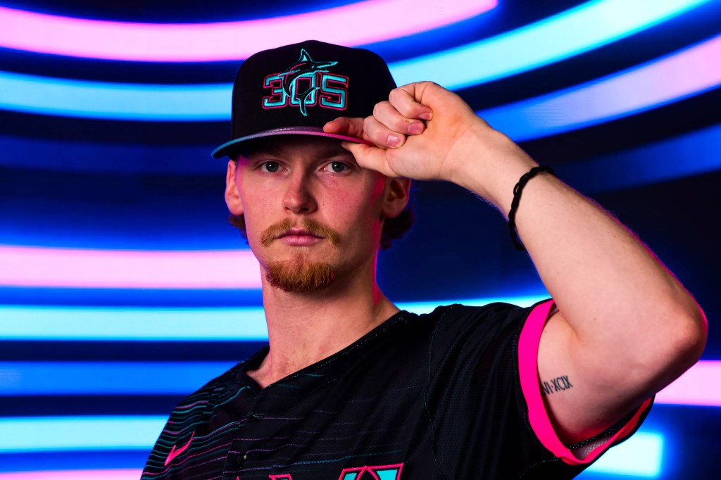 Max Meyer poses with a black hat that says "305" on it in blue and pink