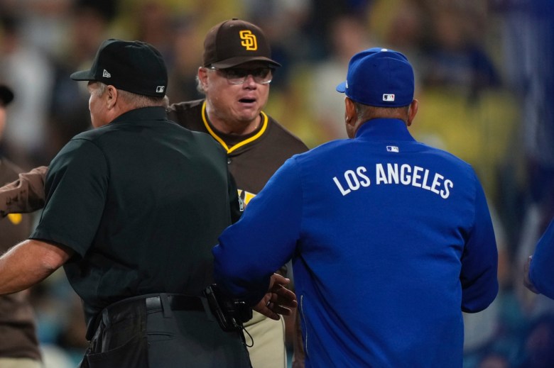An umpire, left, watches as manager Mike Shildt, center, and Dodgers manager Dave Roberts yell at each other.