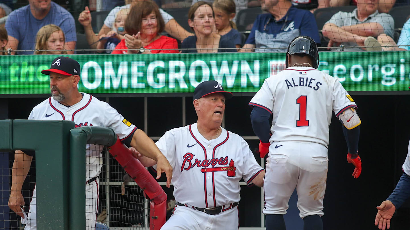 Former Atlanta Braves manager Brian Snitker (43) talks to second baseman Ozzie Albies (1) after scoring a run against the Detroit Tigers in the first inning at Truist Park. Mandatory Credit: Brett Davis-Imagn Images