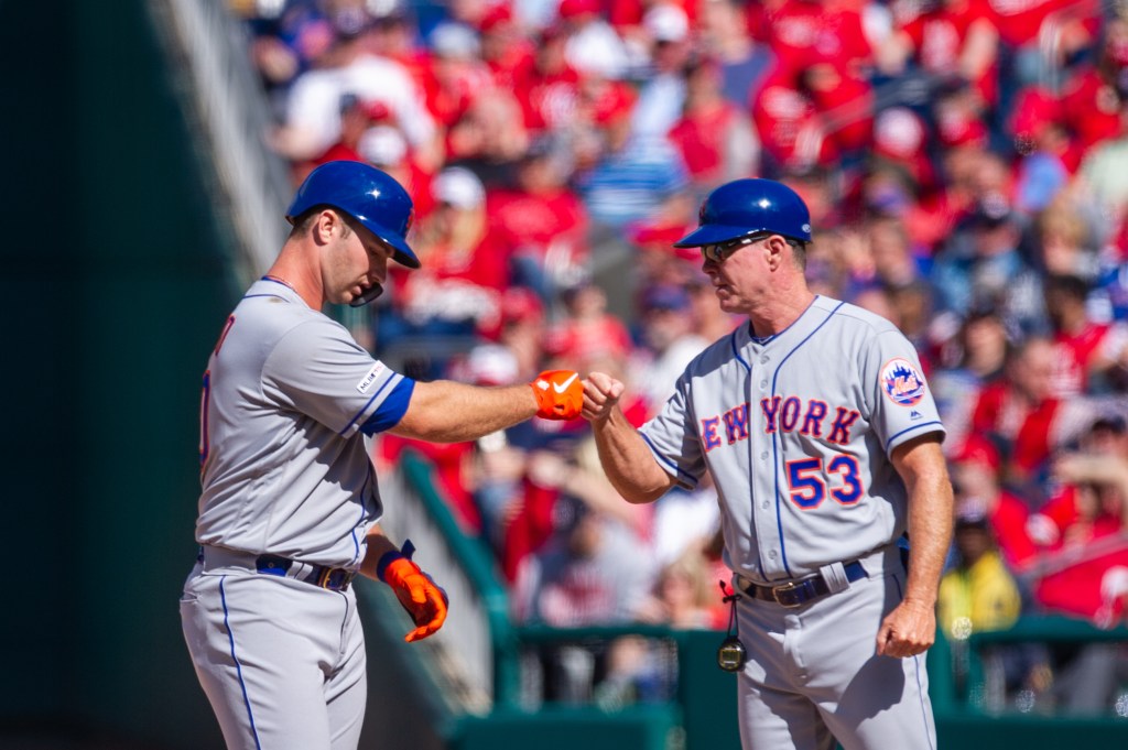 Pete Alonso and Glenn Sherlock of the New York Mets celebrate a hit with a fist bump.