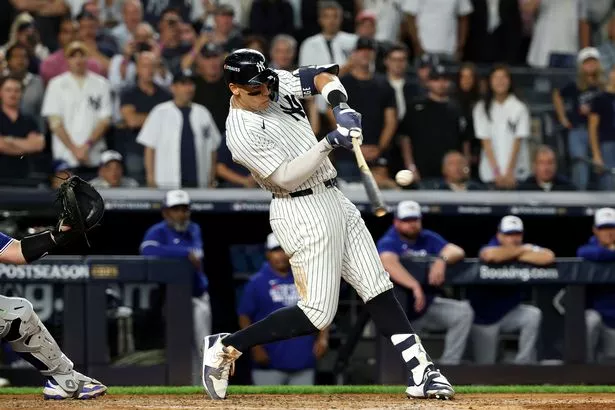 Aaron Judge #99 of the New York Yankees hits a three-run home run against the Toronto Blue Jays during the fourth inning in game three of the American League Division Series at Yankee Stadium